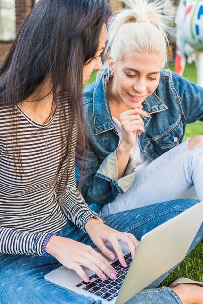 Primer plano de dos hermosas mujeres usando laptop