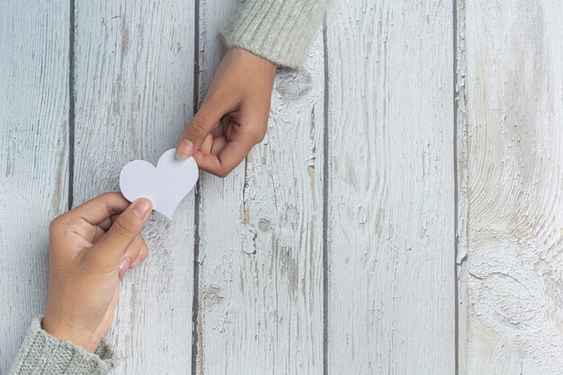 Primer plano de dos jóvenes amantes tomados de la mano en una mesa.