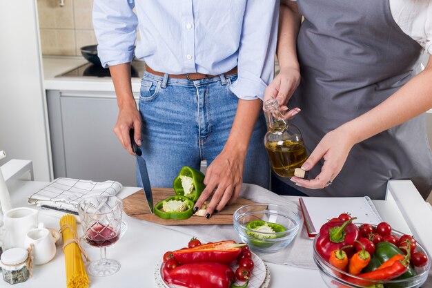 Primer plano de dos mujeres preparando la comida juntos en la cocina