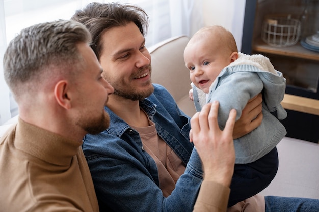 Primer plano de dos papás y un bebé