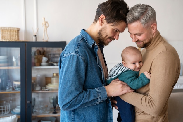 Foto gratuita primer plano de dos papás y un bebé