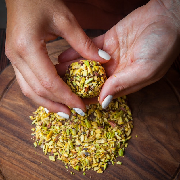 Foto gratuita primer plano de dulces hechos a mano dulces hechos a mano de nueces, frutas secas y miel sobre una superficie de madera oscura