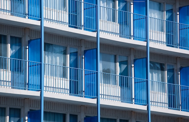 Primer plano de un edificio de apartamentos con divisores de balcón azul