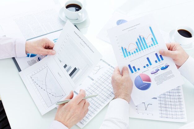 Primer plano de ejecutivos leyendo los gráficos de negocios