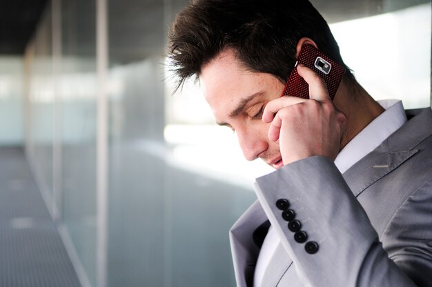 Primer plano de empleado elegante hablando por teléfono