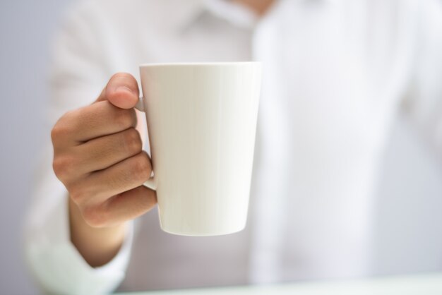 Primer plano de empleado de oficina tomando café de taza