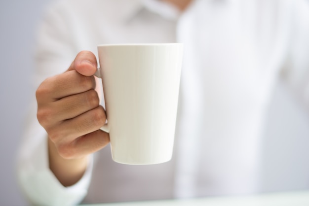 Primer plano de empleado de oficina tomando café de taza