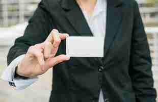 Foto gratuita primer plano de una empresaria mostrando tarjeta de visita en blanco blanco