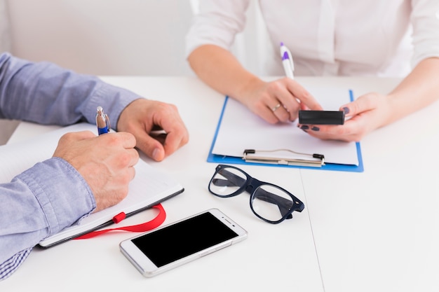 Primer plano de empresario y empresaria trabajando en el lugar de trabajo