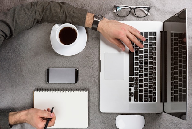 Foto gratuita primer plano de un empresario escribiendo en el portapapeles usando tableta digital en el escritorio