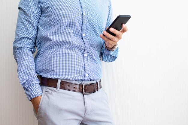 Primer plano de empresario mensajes de texto en el teléfono inteligente