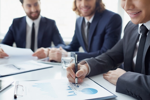 Primer plano de empresario sonriente analizando una gráfica