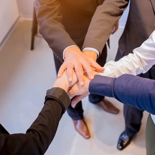 Primer plano de empresarios apilando las manos en la reunión en la oficina