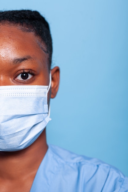 Primer plano de una enfermera especialista afroamericana con mascarilla médica protectora