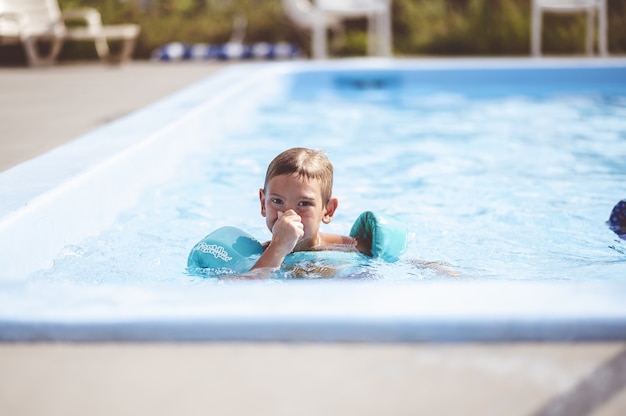 Foto gratuita primer plano de enfoque de un lindo joven nadando en la piscina