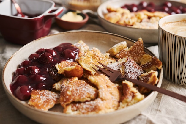 Primer plano de enfoque selectivo de deliciosos panqueques esponjosos con cereza y azúcar en polvo