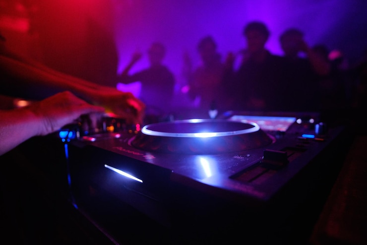 Foto gratuito primer plano del equipo de dj y la gente bailando en el club