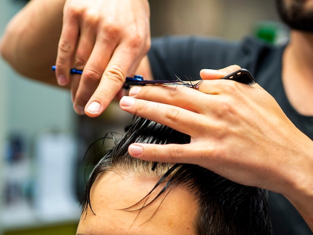 Primer plano de esteticista cortando cabello