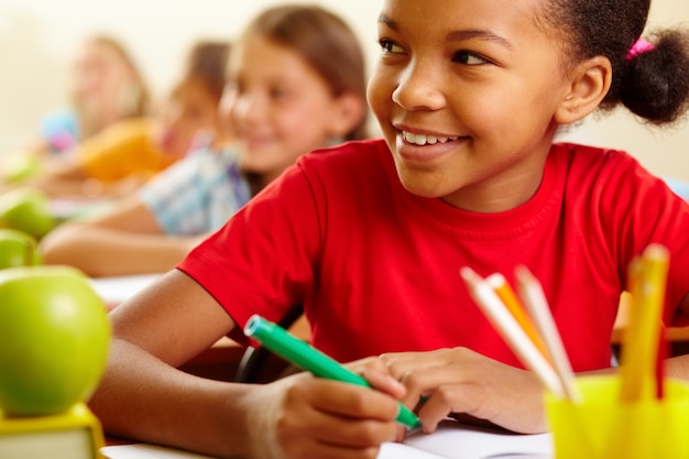 Primer plano de estudiante sonriente con sus compañeros de fondo