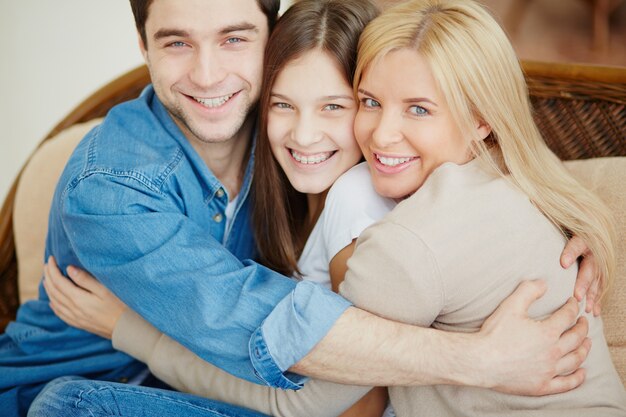 Primer plano de familia feliz abrazándose en casa