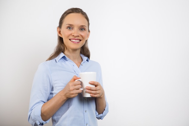 Primer plano de feliz mujer joven bonita que come té