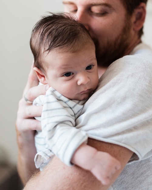 Primer plano feliz padre besando a su hijo