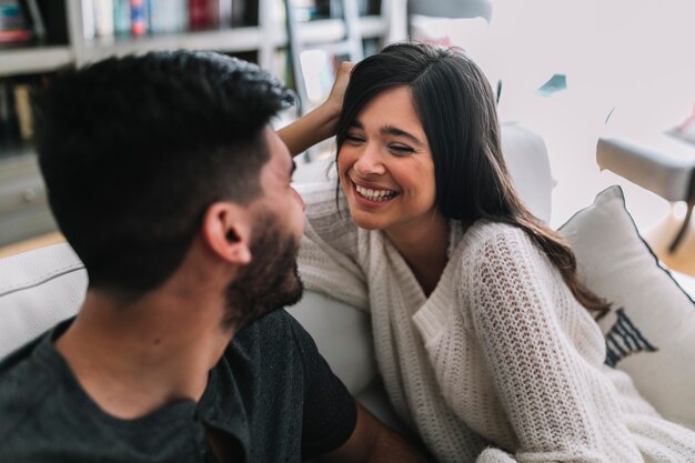 Primer plano de la feliz pareja sentada en el sofá mirando el uno al otro