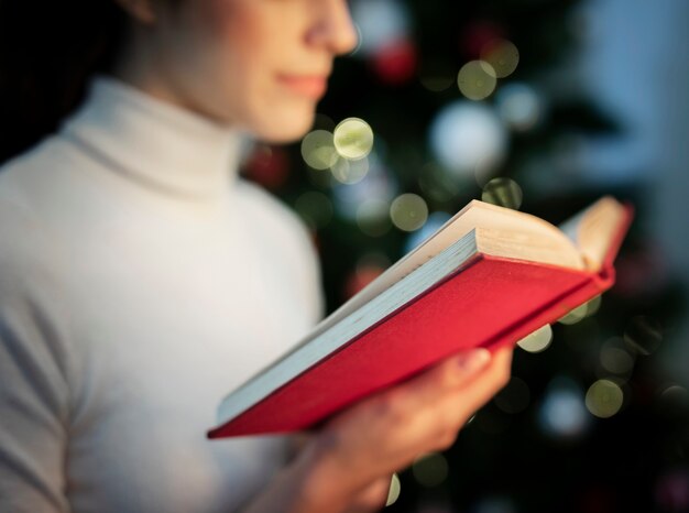 Primer plano femenino leyendo libro de cuentos de navidad