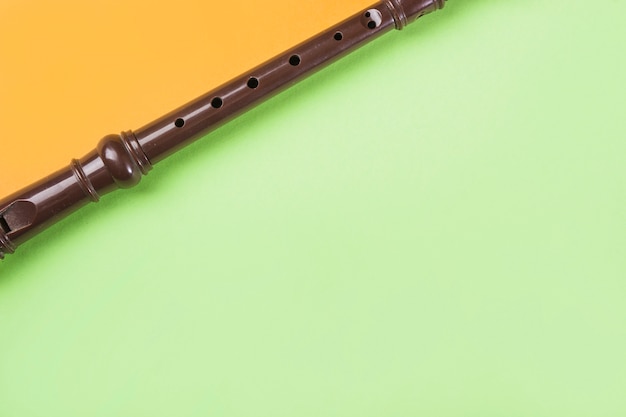 Primer plano de la flauta de bloque en doble fondo naranja y verde