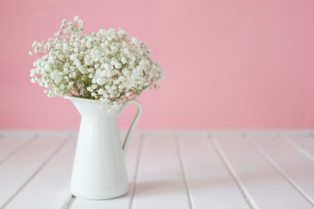 Primer plano de florero blanco con flores