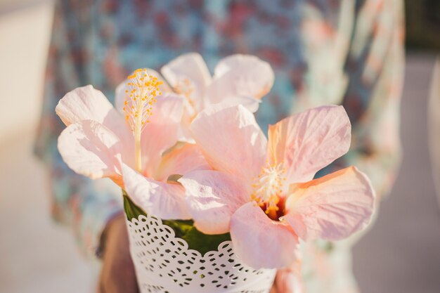 Primer plano de flores bonitas con persona borrosa de fondo