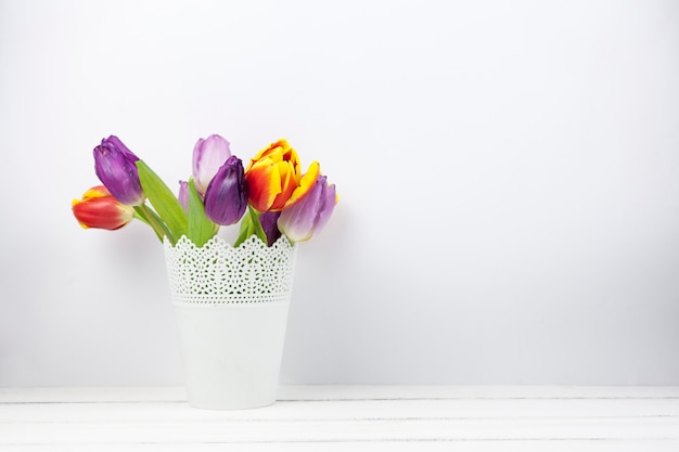 Primer plano de flores de tulipán fresco colorido en florero blanco