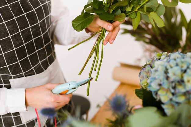 Primer plano florista cortando flores para ramo