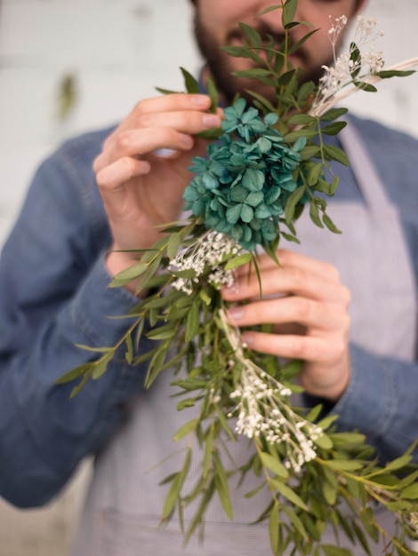 Primer plano de un florista masculino haciendo corona