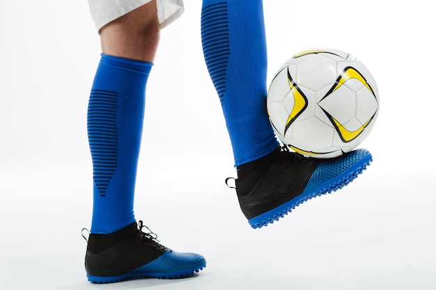 Primer plano de futbolista con balón en el pie