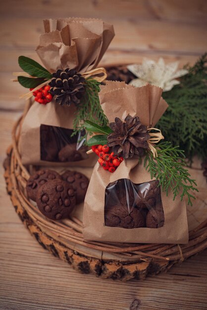 Primer plano de las galletas de chocolate dulce en paquetes de papel decorativo en el tronco de un árbol