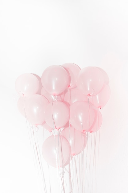 Foto gratuita primer plano de globos de color rosa para la decoración de cumpleaños contra el fondo blanco