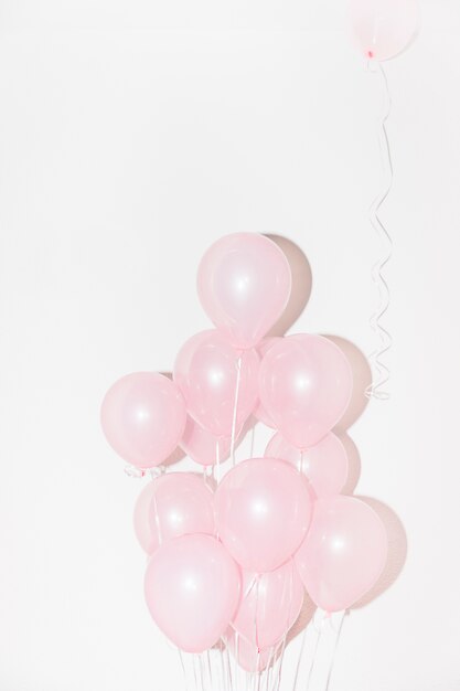 Primer plano de globos de color rosa sobre fondo blanco