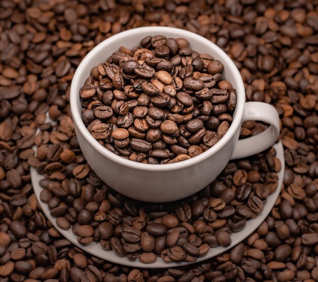 Primer plano de granos de café tostados en una taza
