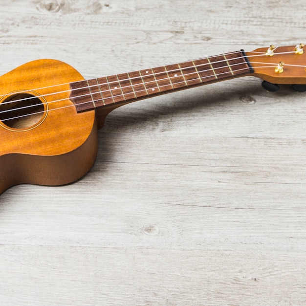 Foto gratuita primer plano de la guitarra acústica de madera en la mesa