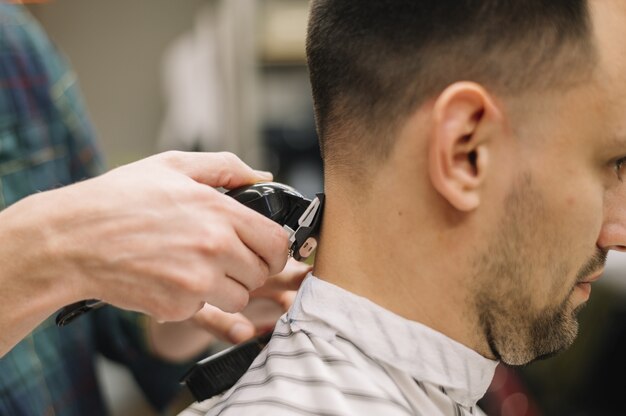 Primer plano de hairstilyst dando un corte de pelo