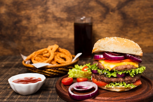 Primer plano de hamburguesa con soda y aros de cebolla