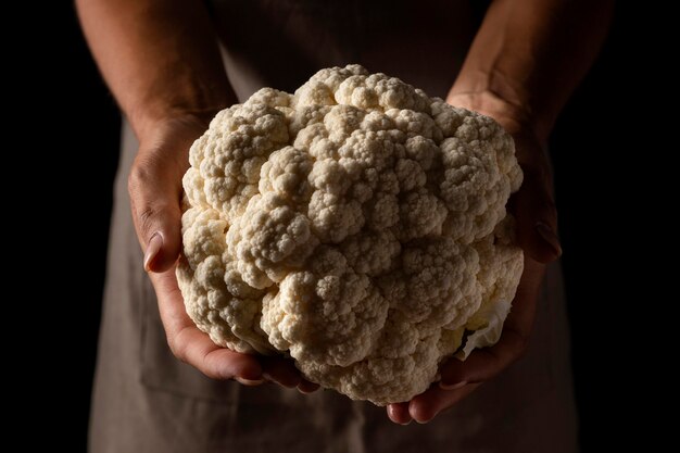 Primer plano hembra sosteniendo coliflor