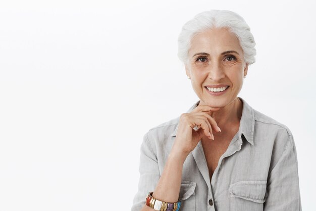 Primer plano de la hermosa anciana sonriente mirando complacido e interesado