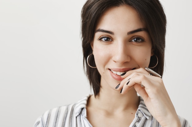 Primer plano de una hermosa morena soñadora que parece tentadora