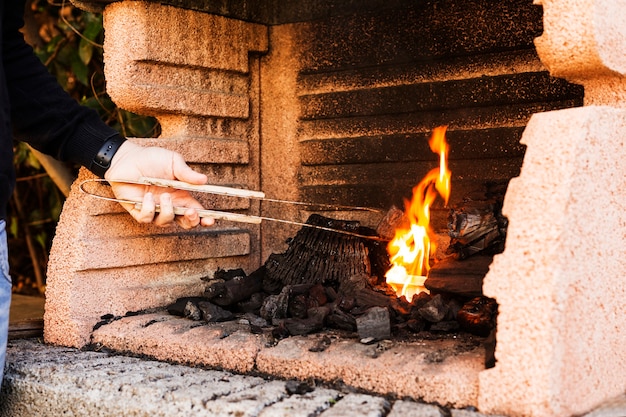 Primer plano de la hoguera ardiente de la mano de una persona