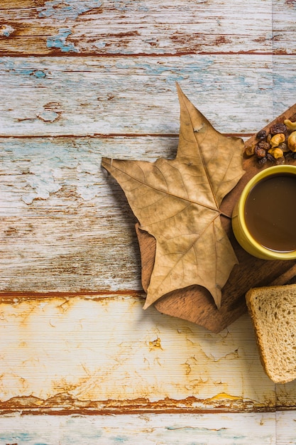 Foto gratuita primer plano de hoja y pasas cerca de café y pan