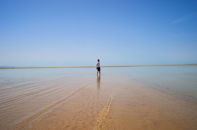 Primer plano de un hombre caminando por la playa en un día soleado