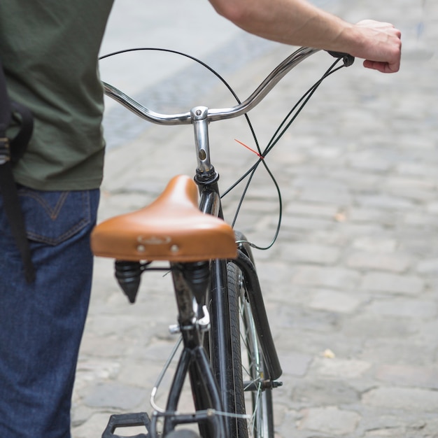 Foto gratuita primer plano de hombre caminando con su bicicleta