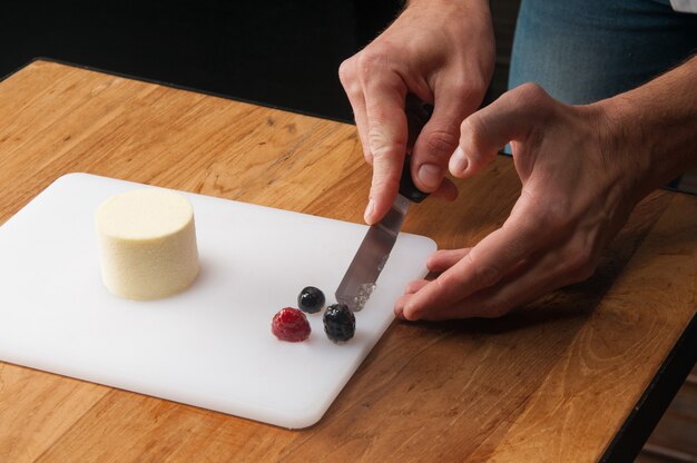 Primer plano de hombre cocinando helado con fresas en mesa